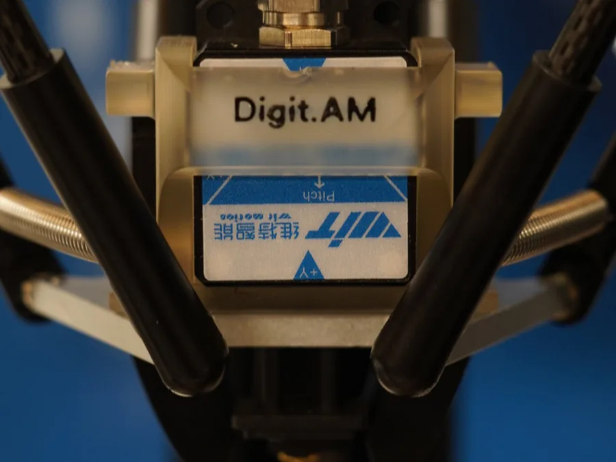 Close-up of the ten-axis inertial sensor mounted on the Digit.AM effector, between the delta arms.