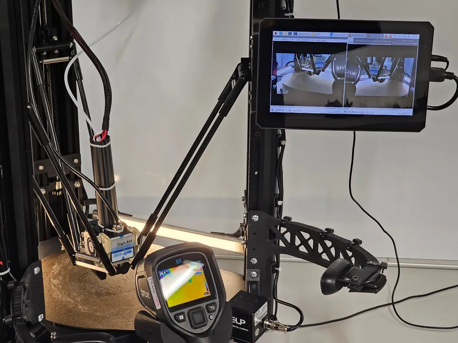 The effector above the build plate, the thermal camera, and the control screen showing live views from two cameras.